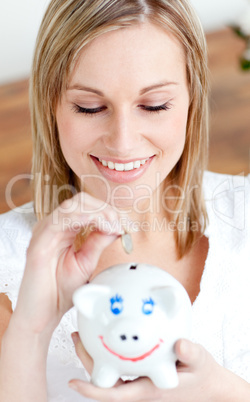 Delighted woman saving money in a piggy-bank