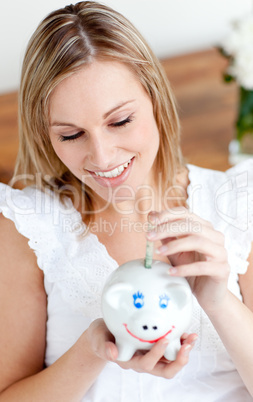 Beautiful woman saving money in a piggy-bank