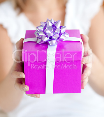 Close-up of a woman holding a present sitting on the floor