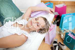 Blond woman relaxing after shopping surrounded with shopping bag