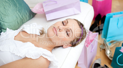 Beautiful woman relaxing after shopping surrounded with shopping