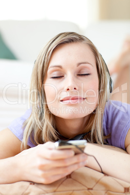 Relaxed woman listening music lying on the floor