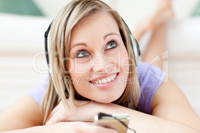 Charming woman listening music lying on the floor