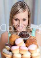 Charming woman holding a plate of cakes