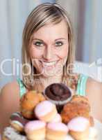 Bright woman holding a plate of cakes