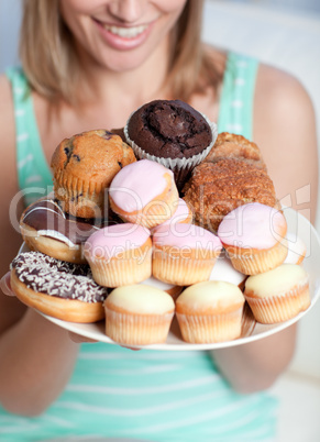 Blond woman holding a plate of cakes