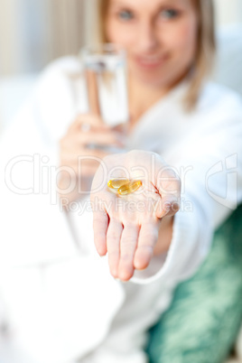 Sick woman holding a glass of water and pills
