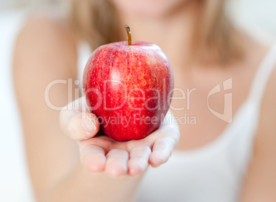 Close-up of a woman showing an apple