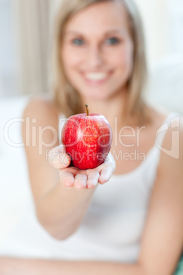 Cheerful woman showing an apple