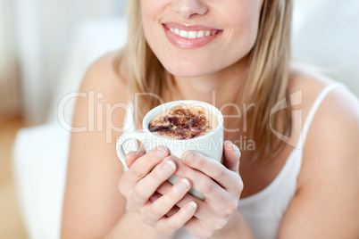 Close-up of a cheerful woman drinking a coffee