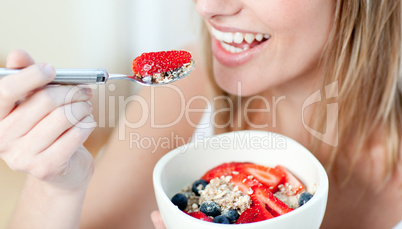 Close-up of a woman eating muesli with fruits