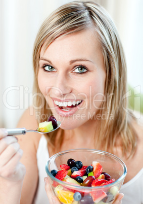 Glowing woman eating a fruit salad