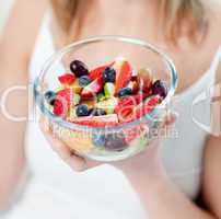 Close-up of a caucasian woman eating a fruit salad