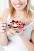 Blond woman eating a fruit salad