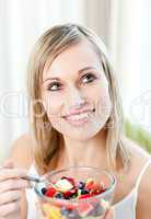 Radiant woman eating a fruit salad