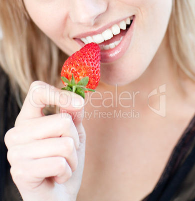 Caucasian woman eating a strawberry