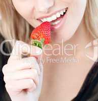Caucasian woman eating a strawberry