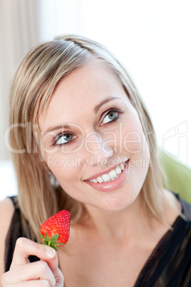 Bright woman eating a strawberry