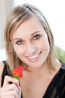 Charming woman eating a strawberry