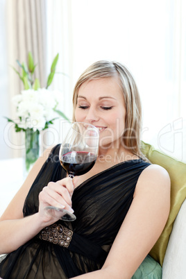 Delighted blond woman drining red wine