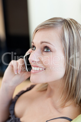Charming woman talking on phone sitting on a sofa