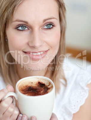 Beautiful woman drinking a coffee sitting on a sofa