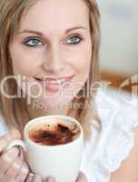 Beautiful woman drinking a coffee sitting on a sofa