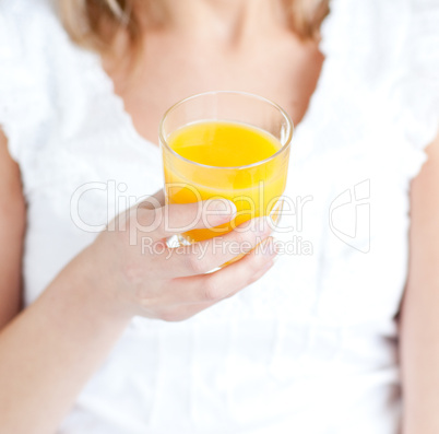 Close-up of a young woman holding an orange juice