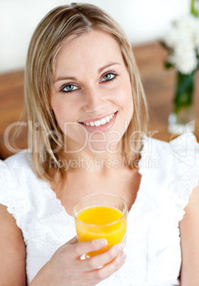 Portrait of a smiling woman holding an orange juice