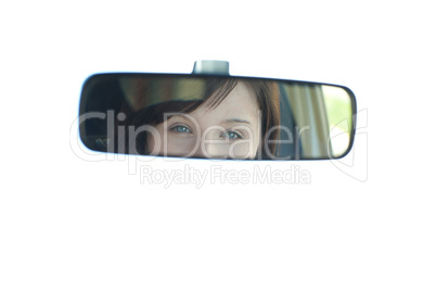 Young woman looking in the rear-view mirror