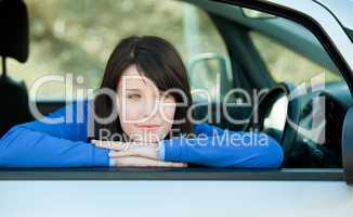 Attractive teen girl smiling at the camera sitting in her car