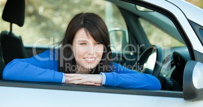 Charming teen girl smiling at the camera sitting in her car