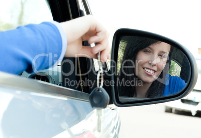 Cheerful teen girl sitting in her car holding keys