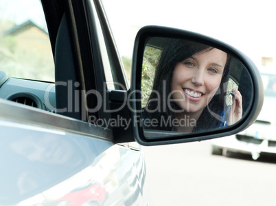 Brunette teen girl sitting in her car holding keys