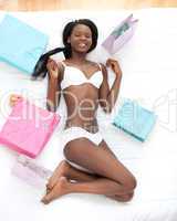 Happy woman surrounded with shopping bags lying on a bed