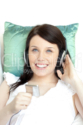 Joyful woman listening music lying on a sofa