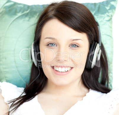 Young woman listening music lying on a sofa