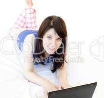 Attrative woman surfing the internet lying on a bed