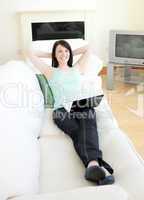 Relaxed woman surfing the internet lying on a sofa