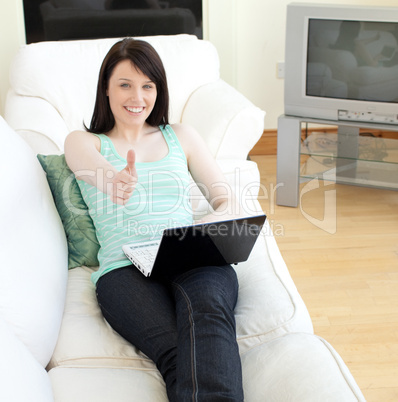 Cheerful woman surfing the internet with a thumb up