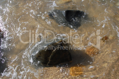 rocks with swirling water on beach