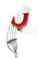 strawberries with cream on a fork isolated on white