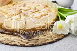 apple pie, fork and tulips on a woven mat