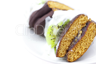 cake with cream and kiwi fruit on a plate isolated on white
