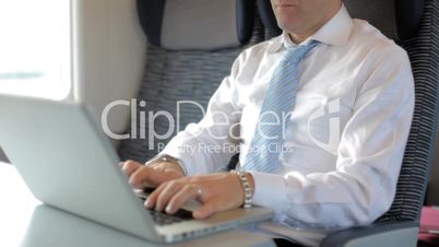 Business man working with laptop computer on train