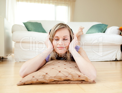 Attractive woman listening music lying on the floor