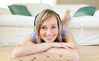 Radiant woman listening music lying on the floor