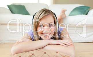 Radiant woman listening music lying on the floor