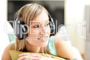 Beautful young woman listening music lying on a sofa