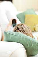 Close-up of a woman sending a text lying on a sofa